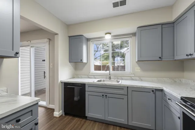 a kitchen with stainless steel appliances granite countertop a sink and dishwasher a stove with wooden floor