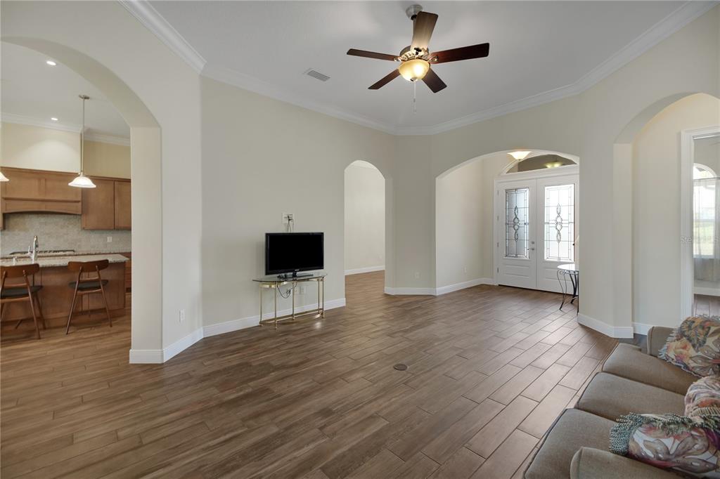 6008 Apex Way Lady Lake, FL 32159 - Photo 23 of 93 a view of a livingroom with hardwood floor and a ceiling fan