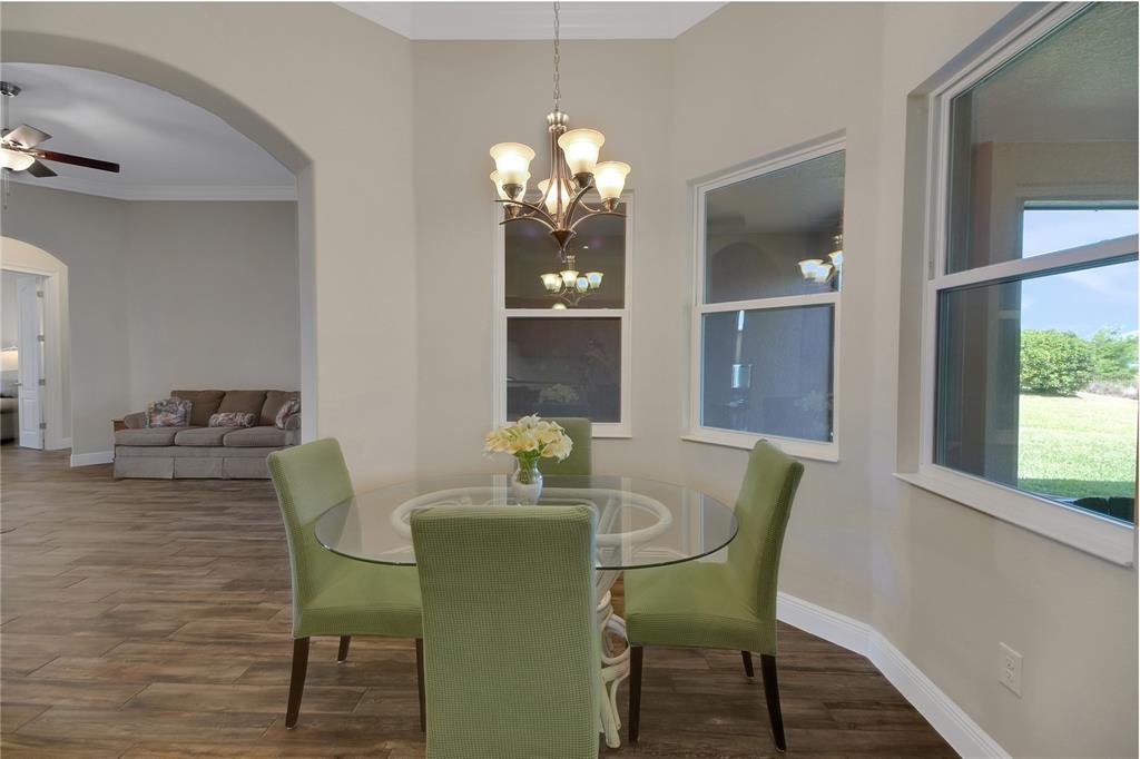 6008 Apex Way Lady Lake, FL 32159 - Photo 24 of 93 a dining room with furniture a chandelier and wooden floor