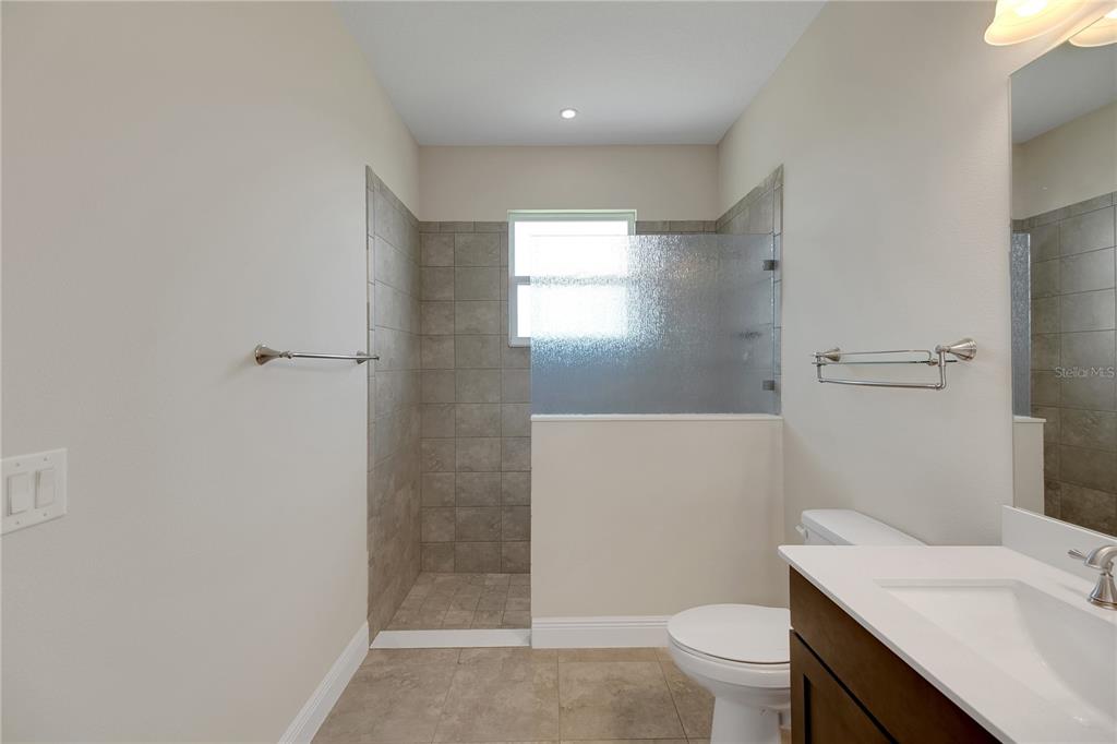 6008 Apex Way Lady Lake, FL 32159 - Photo 49 of 93 a bathroom with a sink a toilet a window and vanity