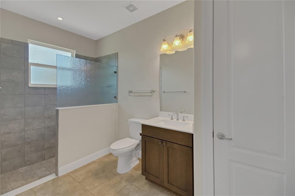 6008 Apex Way Lady Lake, FL 32159 - Photo 50 of 93 a bathroom with a granite countertop sink a toilet and a mirror