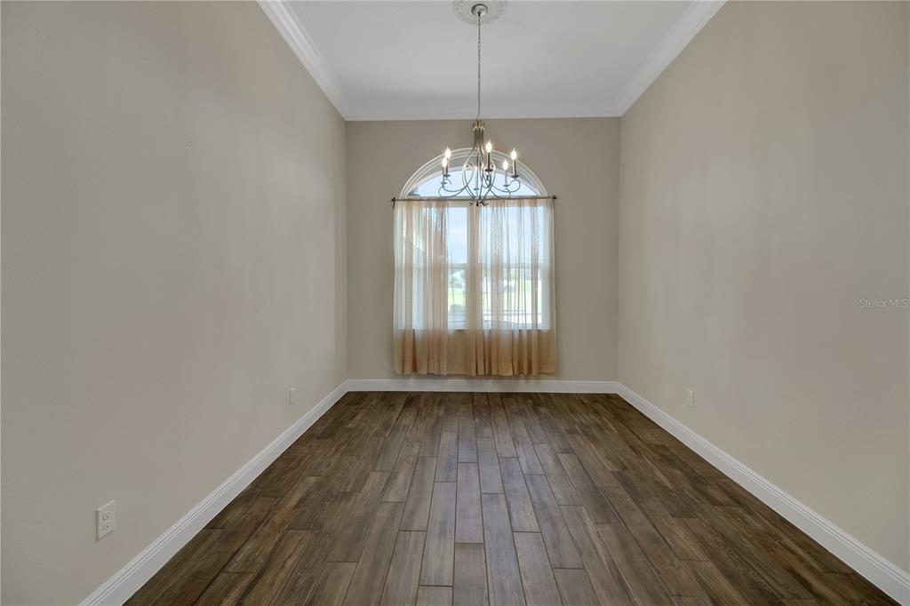 6008 Apex Way Lady Lake, FL 32159 - Photo 60 of 93 a view of an empty room with wooden floor and a window