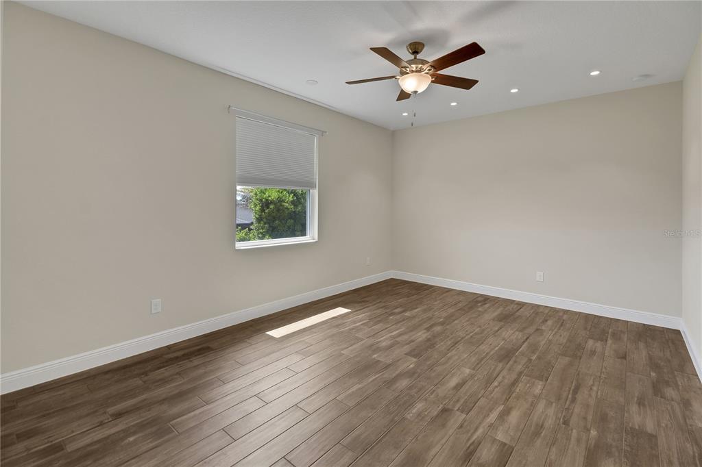 6008 Apex Way Lady Lake, FL 32159 - Photo 65 of 93 an empty room with wooden floor and ceiling fan
