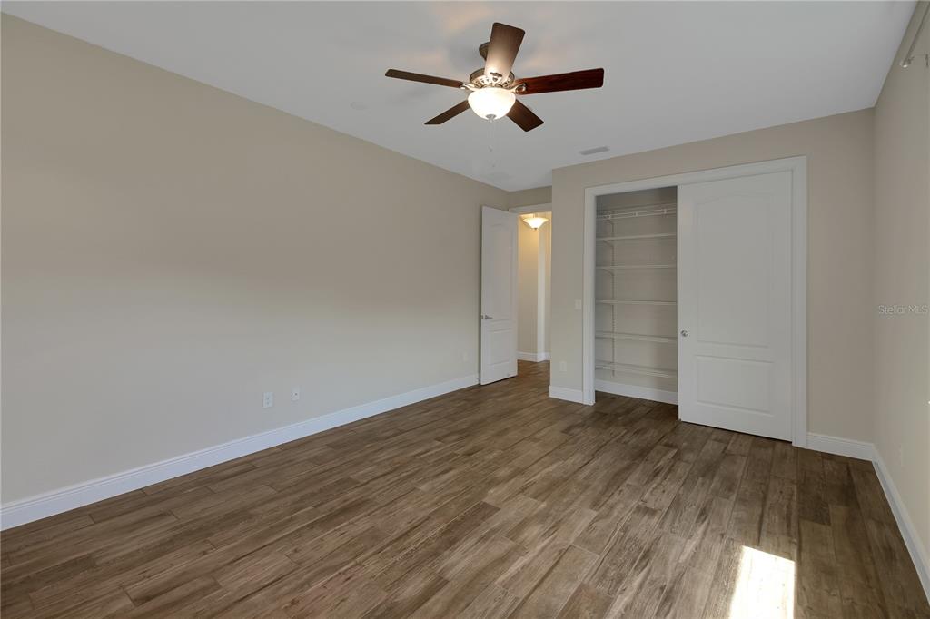 6008 Apex Way Lady Lake, FL 32159 - Photo 66 of 93 an empty room with wooden floor and ceiling fan