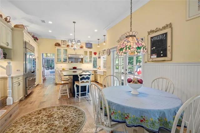a view of a dining room with furniture a chandelier and wooden floor