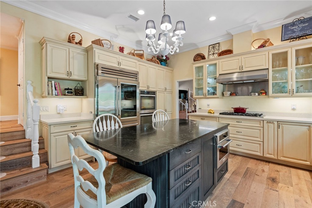 24945 Valley Rim Terrace Lake Forest, CA 92630 - Photo 18 of 52 a kitchen with kitchen island a dining table and chairs