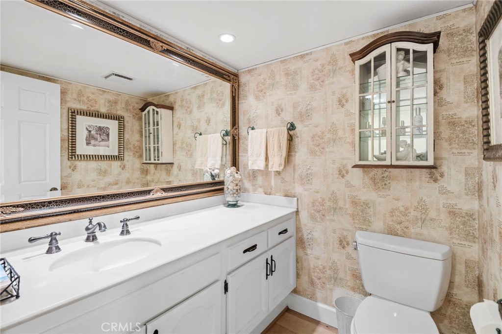 24945 Valley Rim Terrace Lake Forest, CA 92630 - Photo 33 of 52 a bathroom with a granite countertop toilet a sink and a mirror