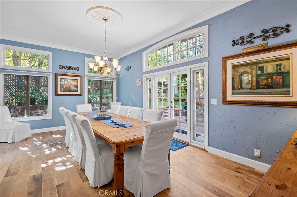 24945 Valley Rim Terrace Lake Forest, CA 92630 - Photo 7 of 52 a dining room with wooden floor a chandelier a wooden table and chairs