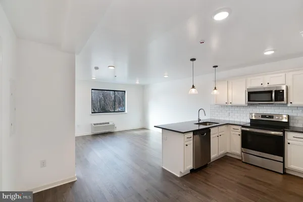 a kitchen with stainless steel appliances granite countertop a sink stove and wooden floor
