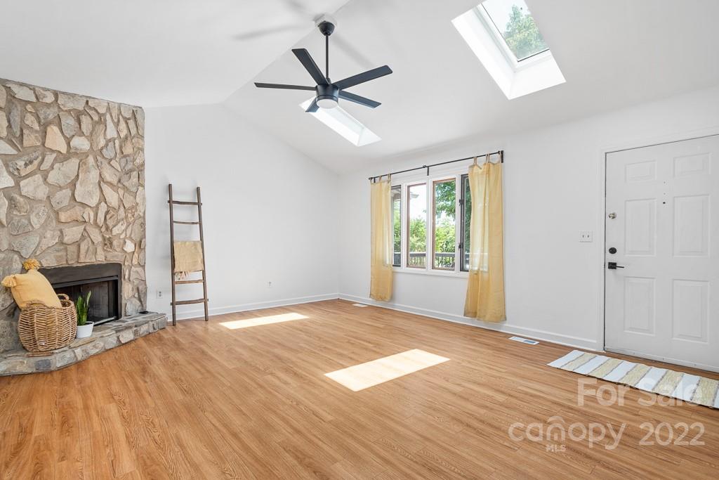 2981 Lake Shore Road South Denver, NC 28037 - Photo 8 of 28 a view of a livingroom with a fireplace a ceiling fan and wooden floor