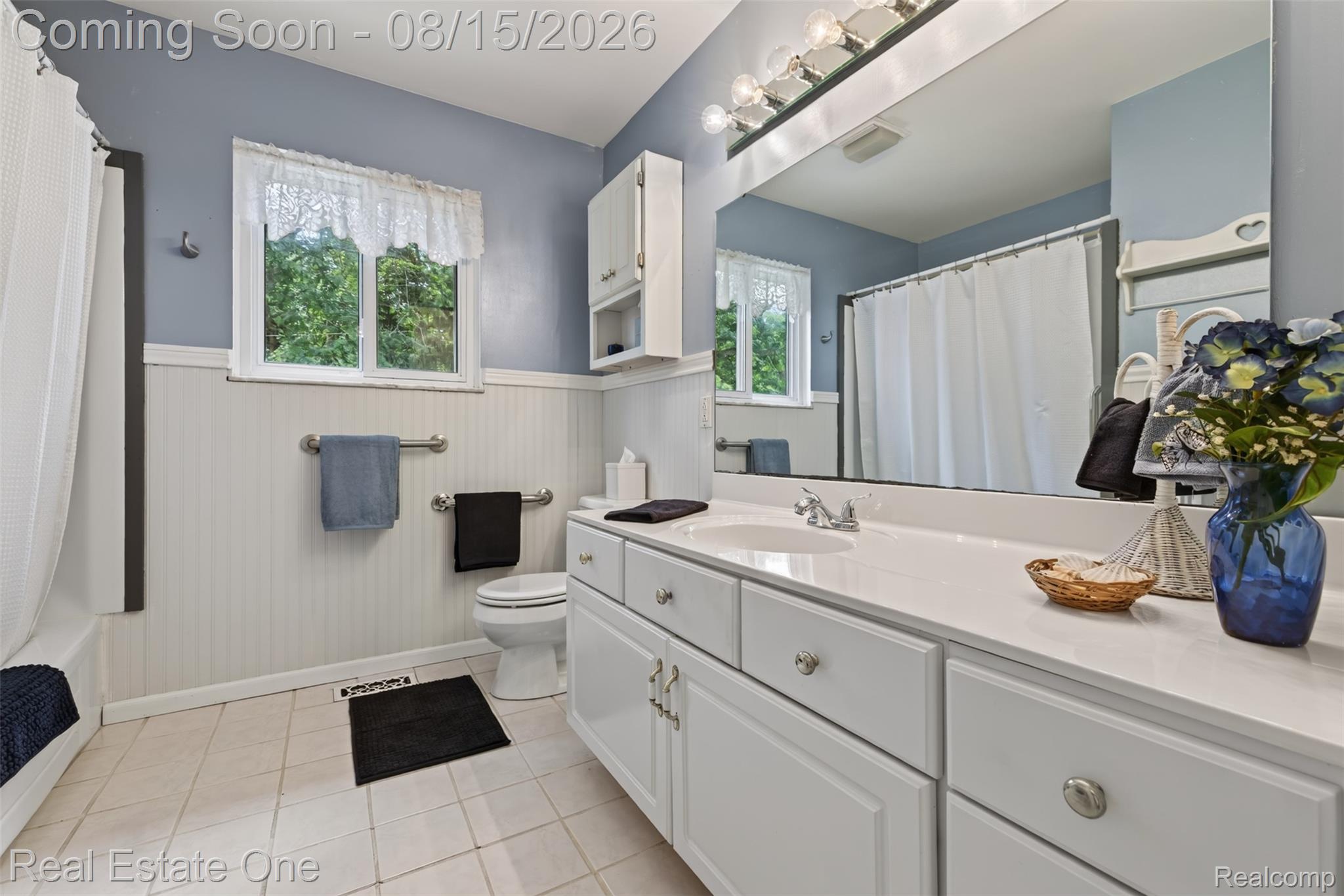 454 South Baldwin Road Oxford, MI 48371 - Photo 23 of 64 Bathroom featuring a white vanity with integrated sink, a large wall-mounted mirror, a two-light window, and beadboard paneling