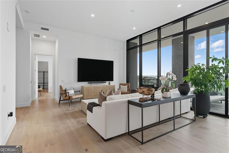 a living room with furniture tv and a large window