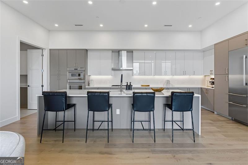 2425 Peachtree Road, Unit 1504 Atlanta, GA 30305 - Photo 5 of 66 a kitchen with stainless steel appliances kitchen island granite countertop a table chairs sink and cabinets