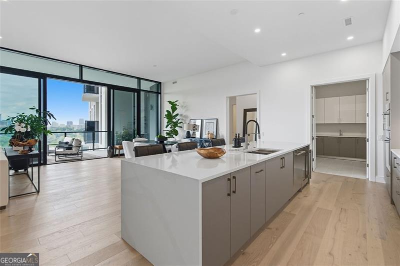 2425 Peachtree Road, Unit 1504 Atlanta, GA 30305 - Photo 9 of 66 a large kitchen with stainless steel appliances a large counter top a sink and a refrigerator