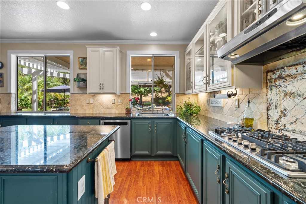 26214 Reade Place Stevenson Ranch, CA 91381 - Photo 21 of 58 a kitchen with stainless steel appliances granite countertop a sink stove and cabinets