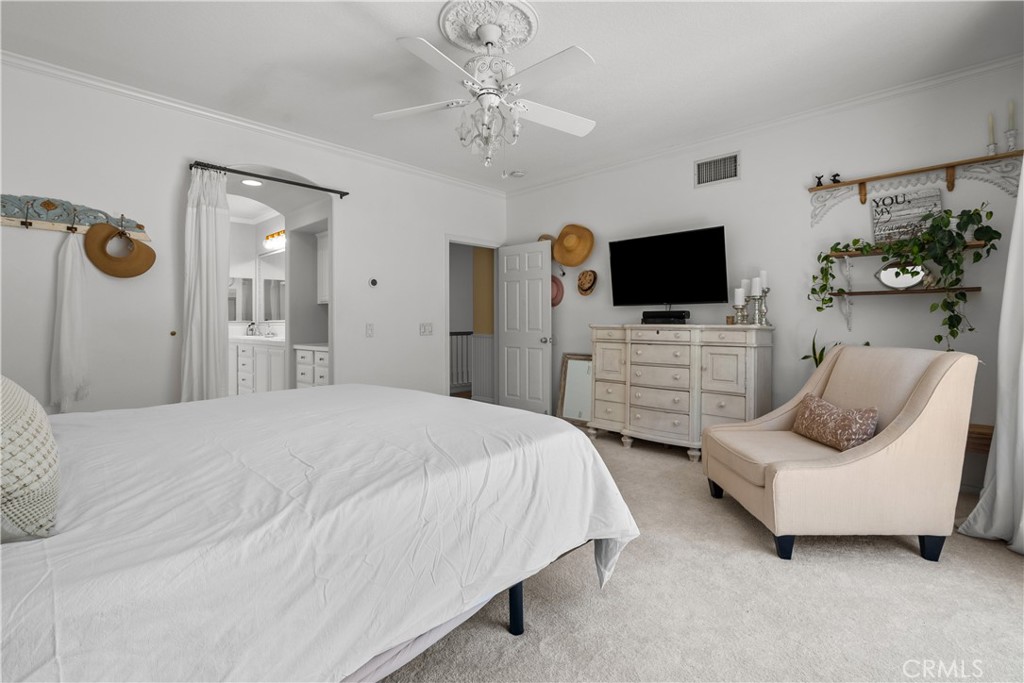 26214 Reade Place Stevenson Ranch, CA 91381 - Photo 36 of 58 a bedroom with a bed a flat screen tv and chandelier