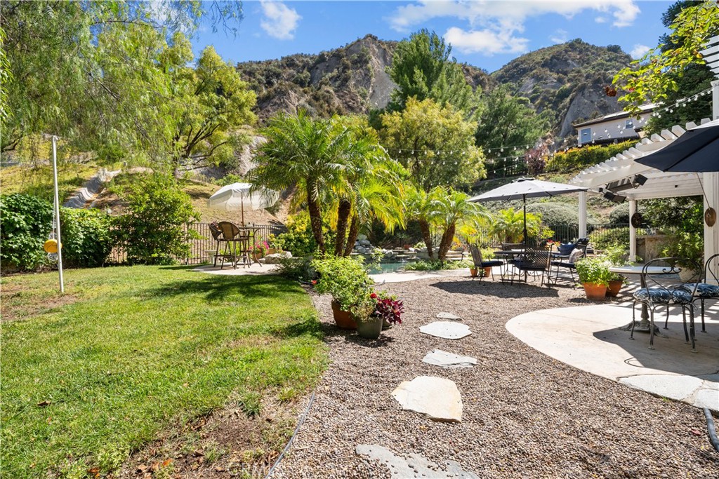 26214 Reade Place Stevenson Ranch, CA 91381 - Photo 8 of 58 a view of a patio with table and chairs potted plants and large tree