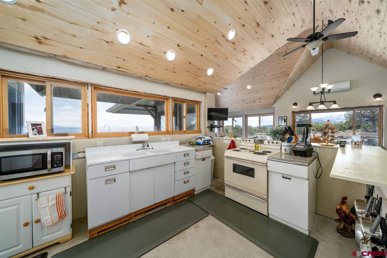20885 Mesawood Road Cedaredge, CO 81413 - Photo 12 of 35 a kitchen that has a lot of cabinets in it and wooden floor