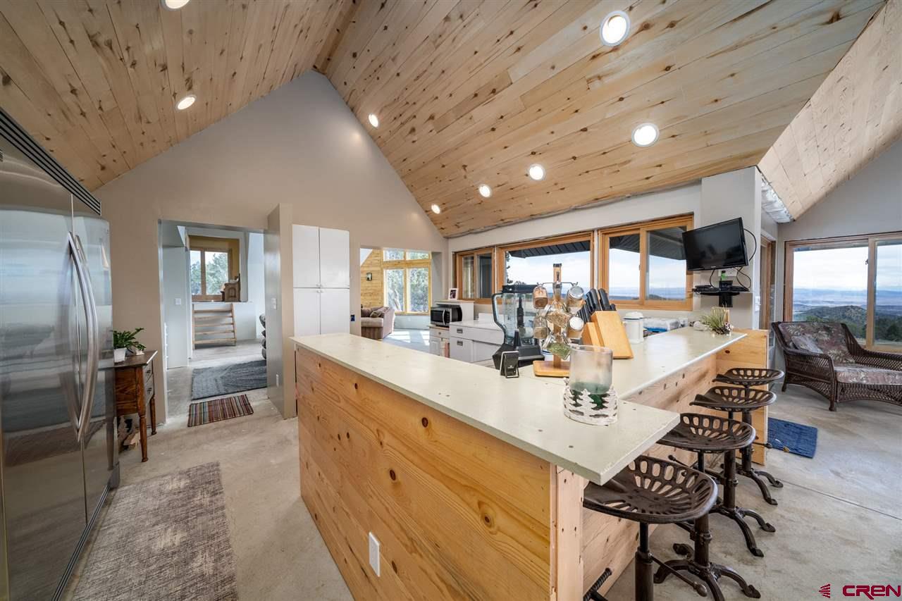 20885 Mesawood Road Cedaredge, CO 81413 - Photo 13 of 35 a large kitchen with dining table chairs and stainless steel appliances