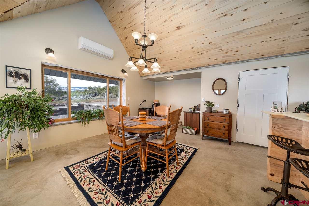 20885 Mesawood Road Cedaredge, CO 81413 - Photo 16 of 35 a dining room with furniture a rug and a chandelier