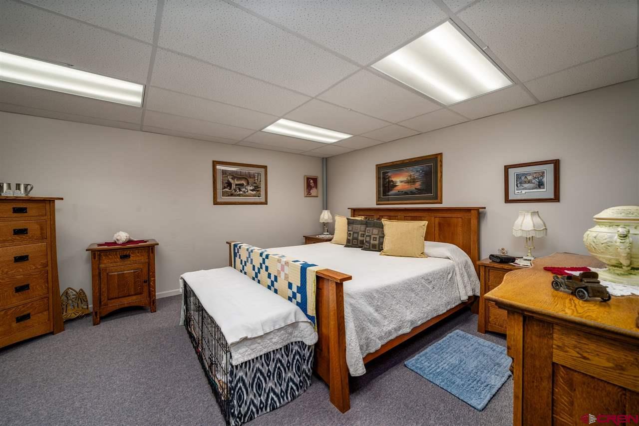 20885 Mesawood Road Cedaredge, CO 81413 - Photo 20 of 35 a bedroom with a bed and a dresser in it