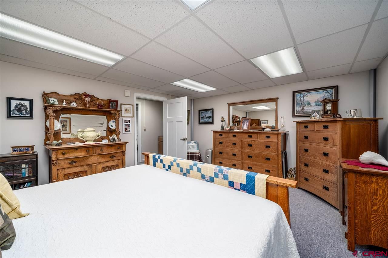20885 Mesawood Road Cedaredge, CO 81413 - Photo 21 of 35 a bedroom with bed and a flat tv screen on dresser