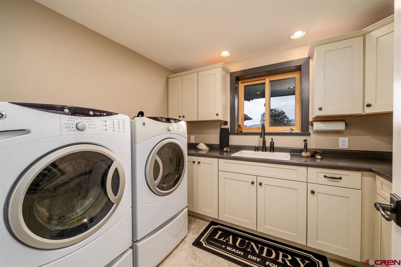 20885 Mesawood Road Cedaredge, CO 81413 - Photo 22 of 35 a utility room with sink dryer and washer