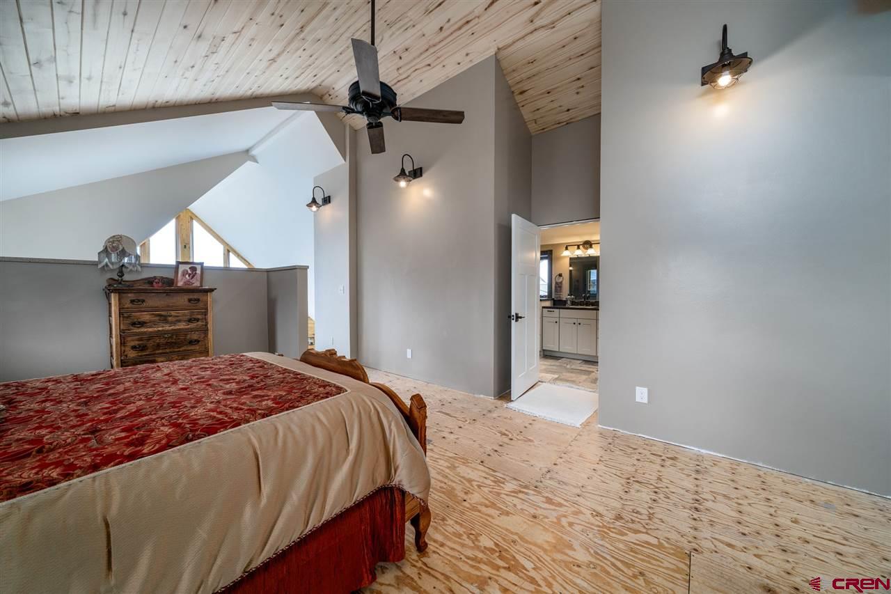20885 Mesawood Road Cedaredge, CO 81413 - Photo 27 of 35 a bedroom with a large bed and a dresser