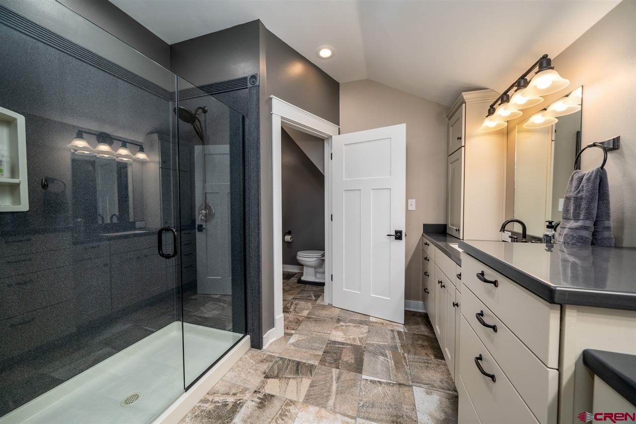 20885 Mesawood Road Cedaredge, CO 81413 - Photo 29 of 35 a bathroom with a double vanity sink toilet and shower