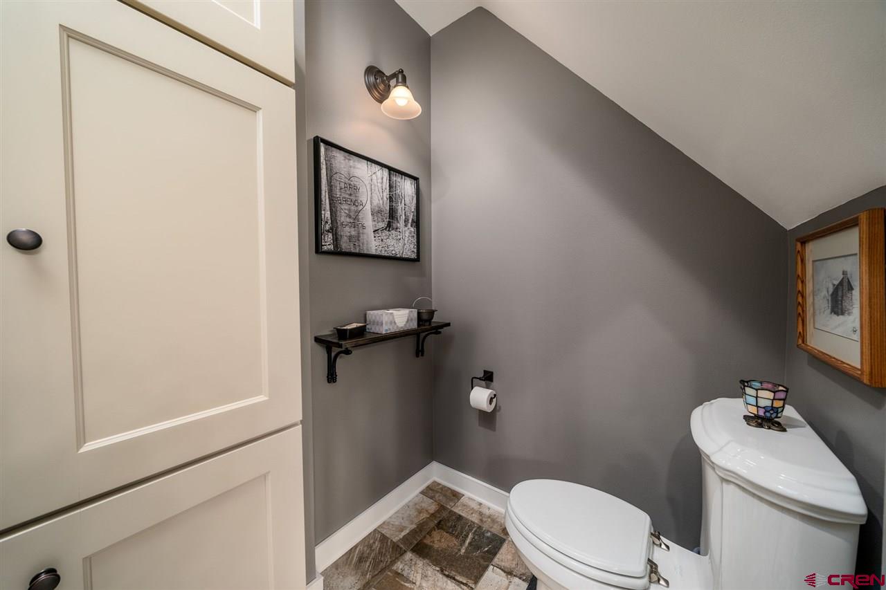 20885 Mesawood Road Cedaredge, CO 81413 - Photo 30 of 35 a white toilet sitting next to a bathroom sink and vanity