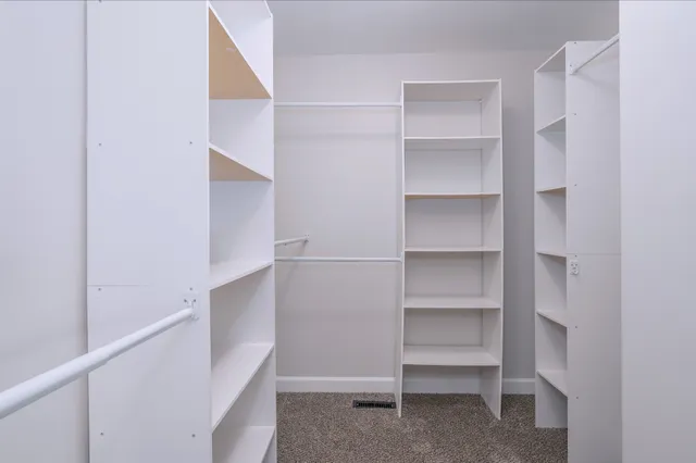 a view of walk in closet with empty racks