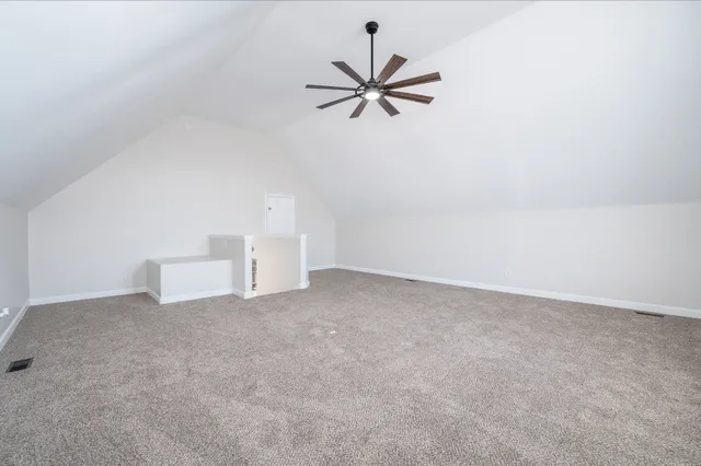 a view of a room with a ceiling fan and window