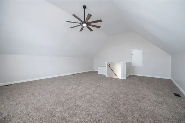 a view of an empty room and chandelier fan