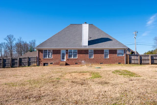 a front view of a house with yard and trees