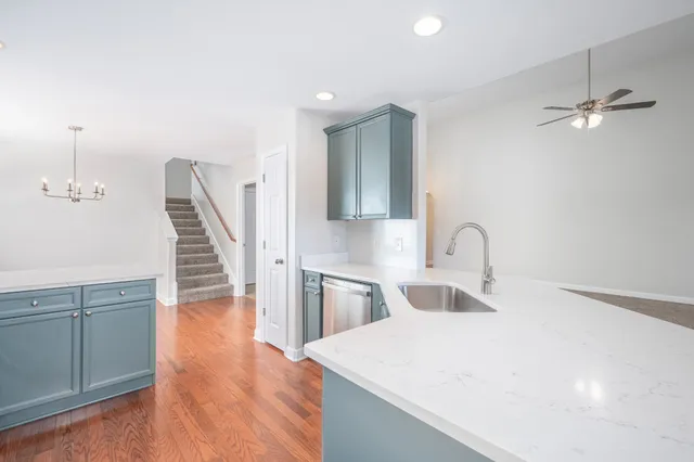 a kitchen with a sink a refrigerator and wooden floor