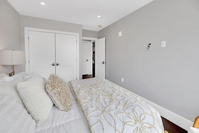 a spacious bedroom with a bed and a lamp