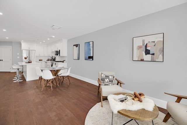 a living room with furniture and a dining table with wooden floor