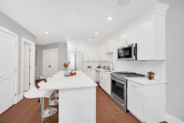 a kitchen with a sink stove and white cabinets