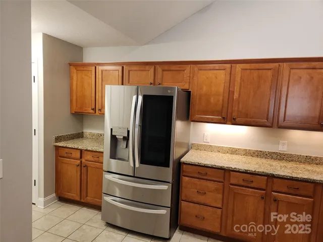 a kitchen with stainless steel appliances granite countertop a refrigerator and a stove top oven