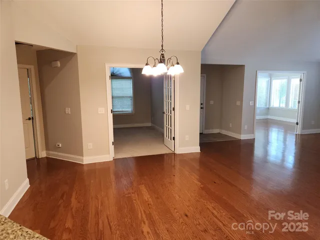 a view of a room with wooden floor and windows