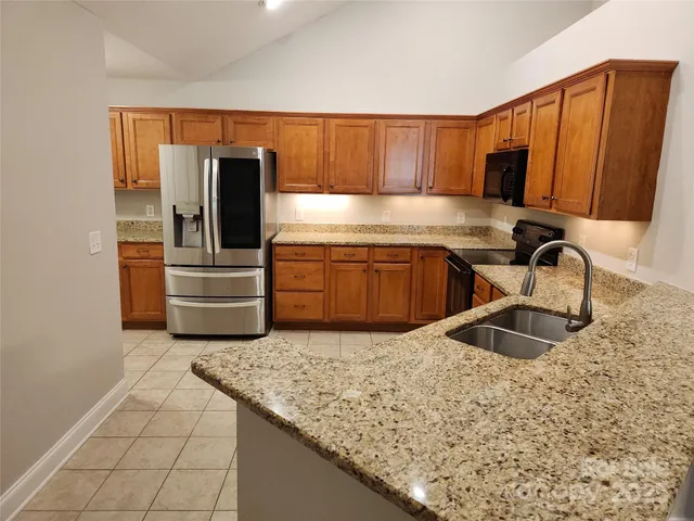 a kitchen with granite countertop a sink and a stove top oven