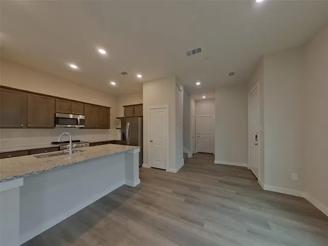 a view of a kitchen with stainless steel appliances granite countertop a refrigerator and a sink
