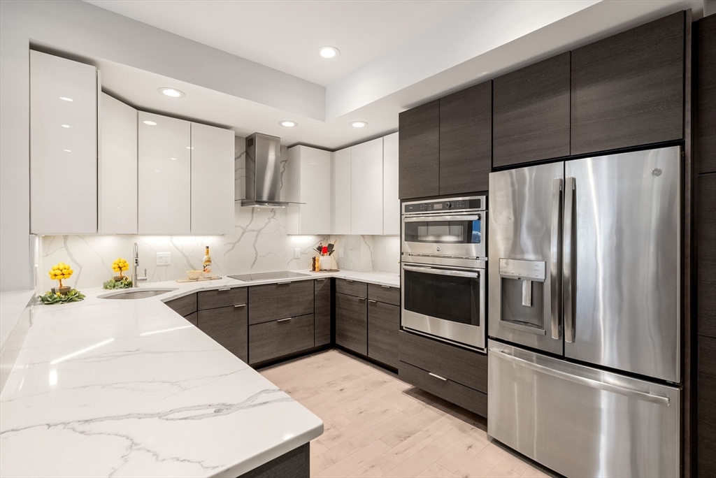 28 Atlantic Avenue, Unit 638 Boston, MA 02110 - Photo 6 of 39 a kitchen with granite countertop stainless steel appliances and refrigerator