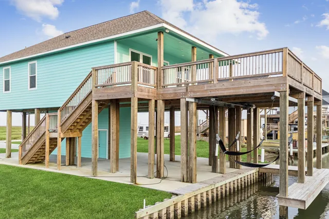 a view of house with a garden and deck
