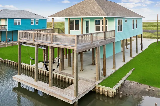 a view of a house with a deck and a yard