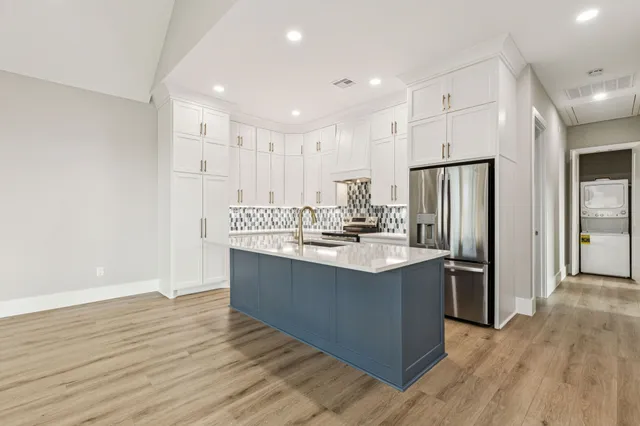 a kitchen with stainless steel appliances granite countertop a sink stove and refrigerator