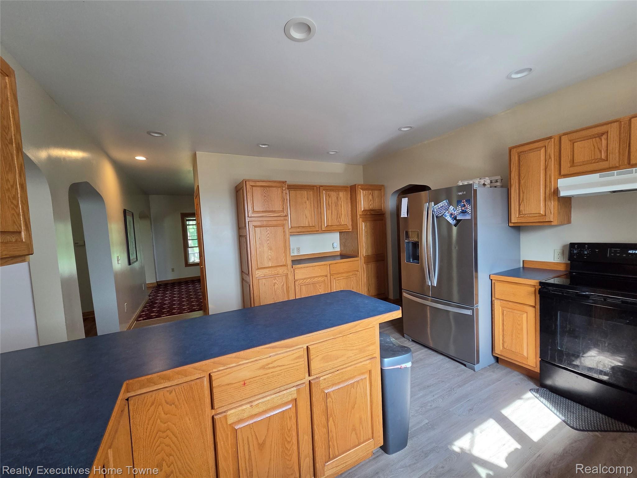 2715 Cash Road Applegate, MI 48401 - Photo 33 of 59 Kitchen featuring wood cabinetry, blue countertops, stainless steel refrigerator, black range, and recessed lighting