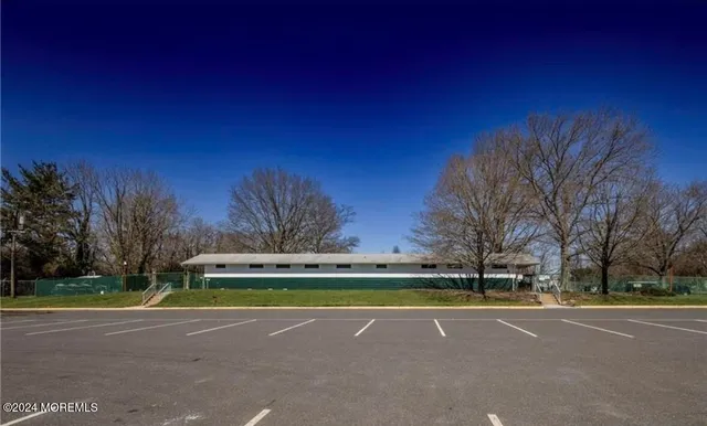 a view of a tennis ground with large trees