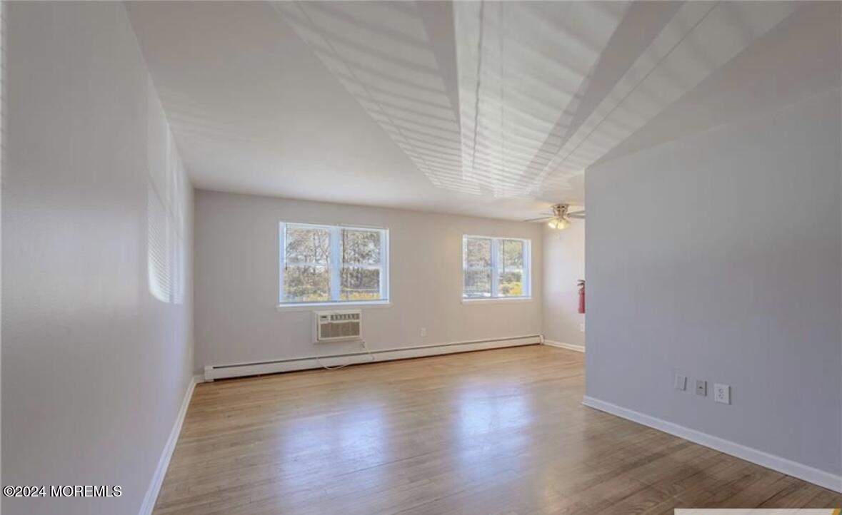 28 Manchester Court, Unit C Freehold, NJ 07728 - Photo 2 of 23 an empty room with wooden floor and windows