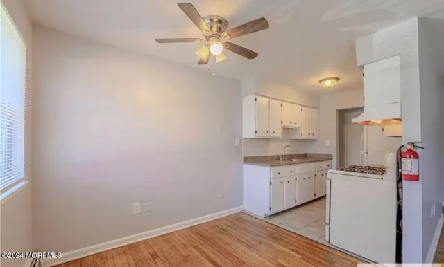 a kitchen with granite countertop cabinets a sink and white stainless steel appliances